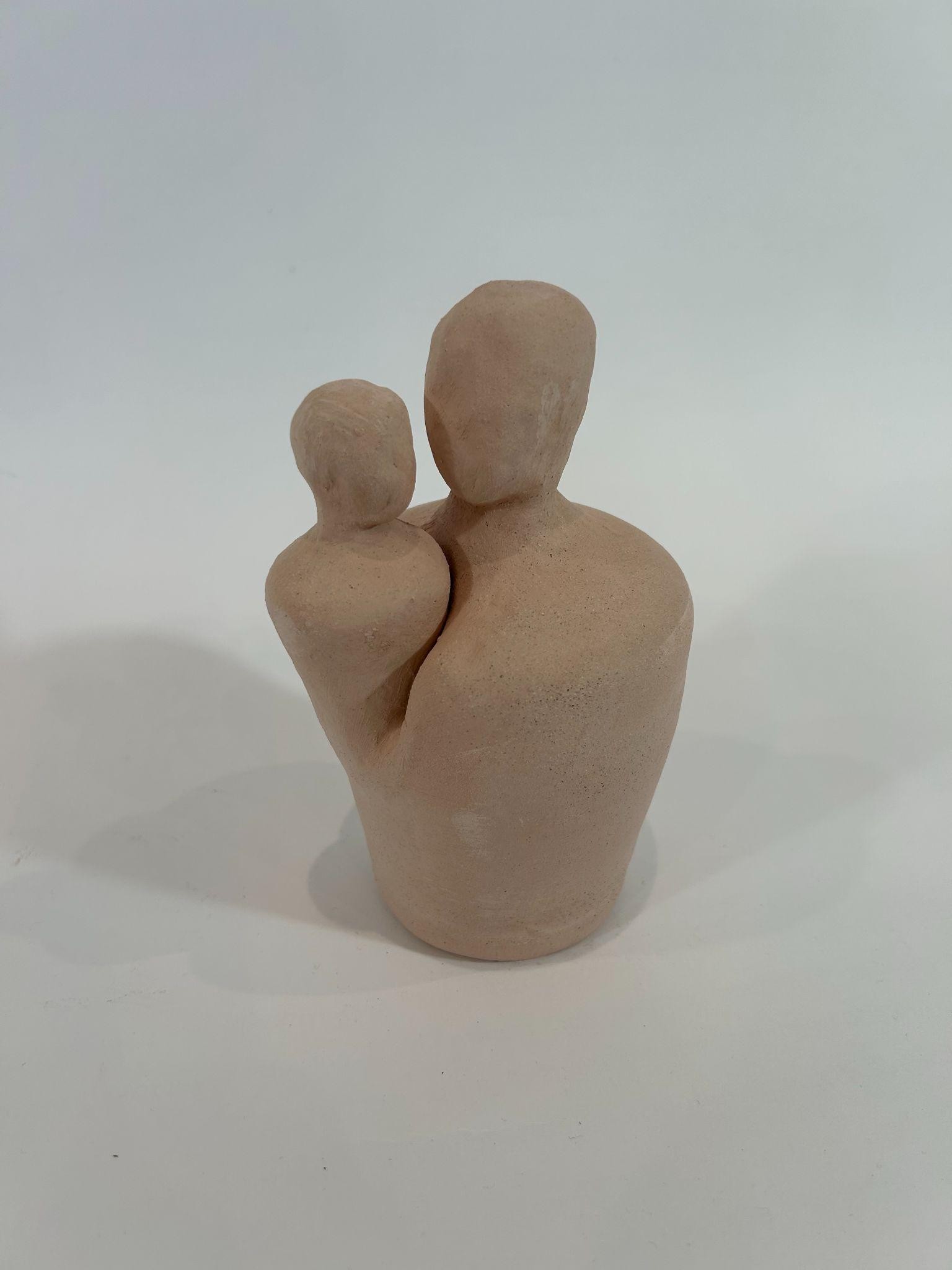An unfired abstract sculpture of two rounded forms leaning together